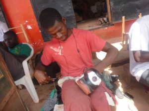 Augustine Teah, who was sponsored by NOCAL to study at Cuttington University, Liberia. When his funding was cut, he was forced to mend shoes to make money. Photo: Jefferson Massah